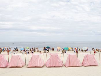 Group of people on beach against sky