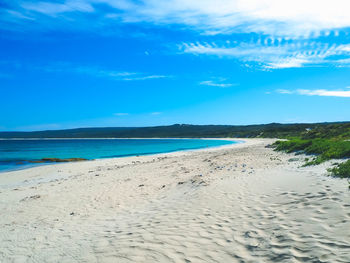 Scenic view of beach against blue sky