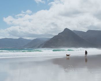 Scenic view of sea and mountains against sky