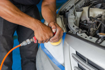 Midsection of man polishing car in garage