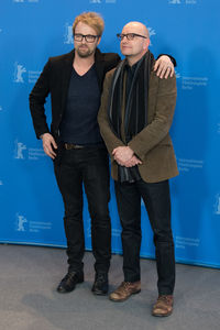 Portrait of friends standing against blue wall