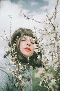 Portrait of woman with pink flowers against blurred background