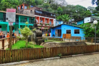 Houses by street in city against buildings