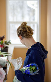 Close-up of woman holding plants at home