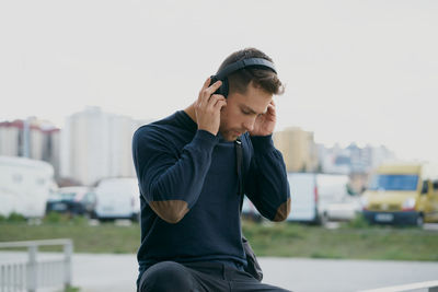 Young man with headphones on city street