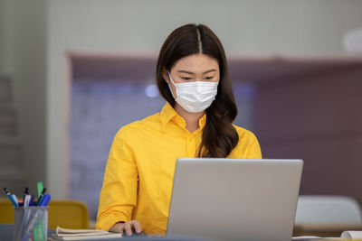 Businesswoman wearing mask working in office