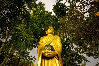 Low angle view of statue against trees