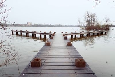 Pier over river against clear sky