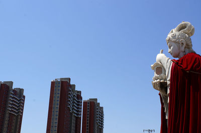 Low angle view of statue against clear blue sky