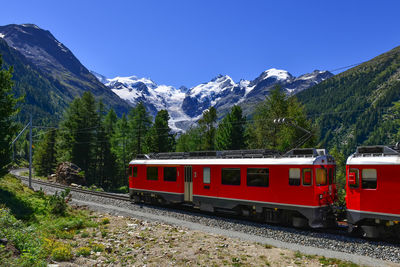 Train on railroad track by mountain against sky