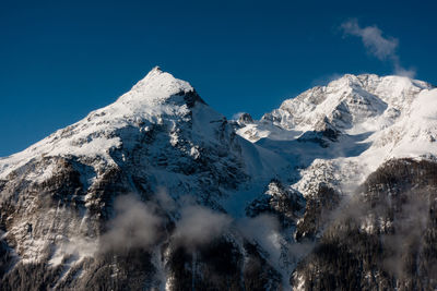 Scenic view of snowcapped mountains against clear blue sky