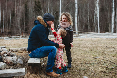 Woman sitting in park during winter