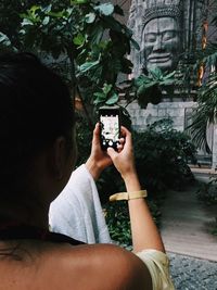 Young woman photographing through smart phone