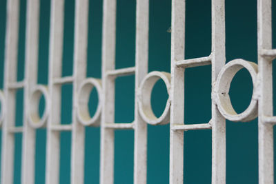 Full frame shot of metal fence against blue wall