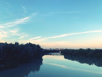 Scenic view of river against sky at sunset