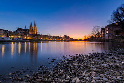 Buildings by river against sky