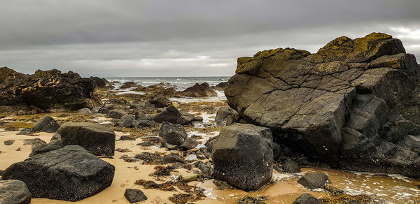 Rocks by sea against sky