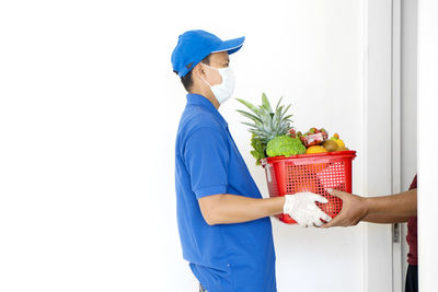 Cropped image of man receiving parcel from delivery person at home