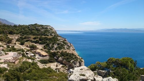 Scenic view of sea and rocks against blue sky