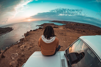 Rear view of woman on beach against sky