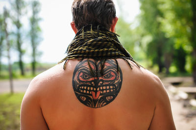 Rear view of shirtless man with tattoo on back