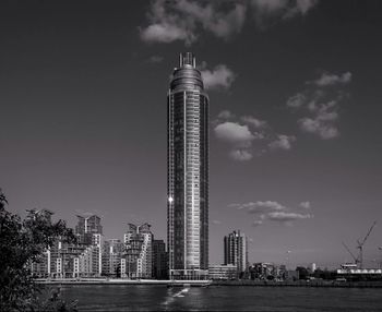 Low angle view of skyscrapers against cloudy sky