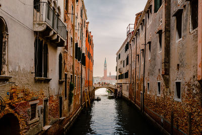 Venice canal with bridge and bell tower in the background