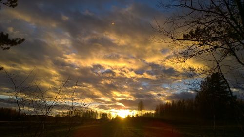 Silhouette landscape against cloudy sky during sunset