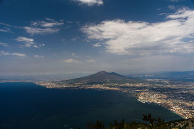 Aerial view of cityscape against cloudy sky