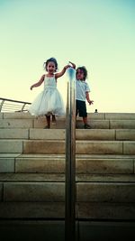 Low angle view of woman standing on railing