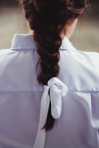 Rear view of woman hair tied with ribbon