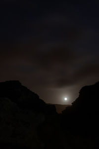 Scenic view of silhouette mountains against sky at night