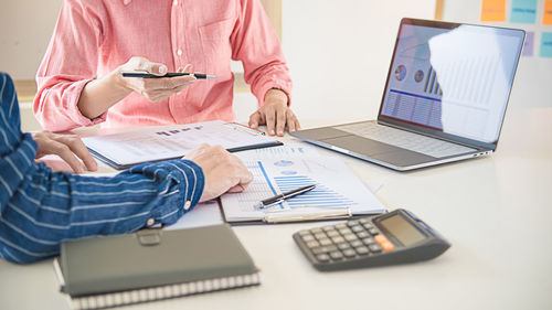 Midsection of man using laptop on table