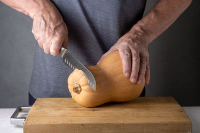 Midsection of man cutting onion on table