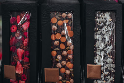 Handmade chocolate bars with dried cranberries, raspberries and pistachios, strawberries, nuts. 
