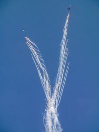 Low angle view of vapor trail against clear blue sky