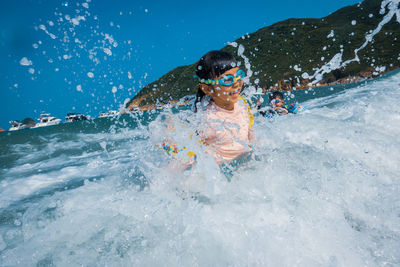 Kid swimming in sea, playing with waves