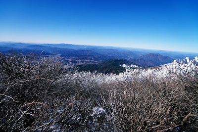 Scenic view of mountains against clear blue sky