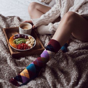 Mid section of a woman eating fruit salad