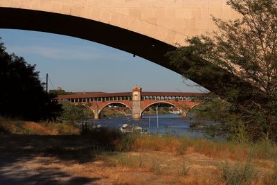 Arch bridge over river against sky