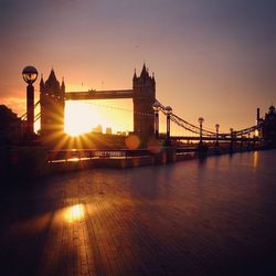 Tower bridge over thames river against sky during sunset