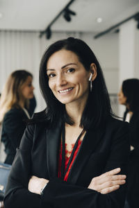 Portrait of businesswoman with arms crossed at workplace