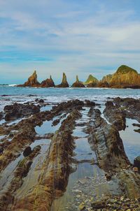 Scenic view of rocks in sea against sky