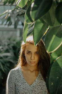 Close up portrait of a young woman amidst plants