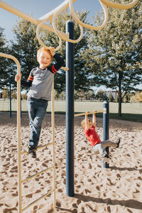 Boy playing on monkey bars at playground