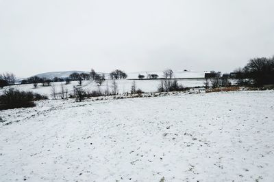 Snow covered landscape against clear sky