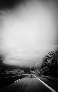 Empty road against cloudy sky