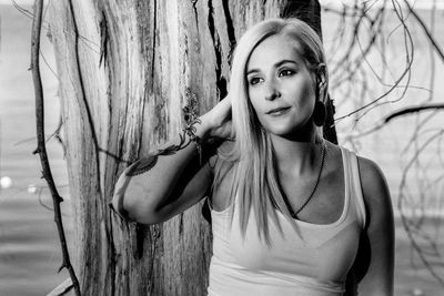 Portrait of woman against tree trunk