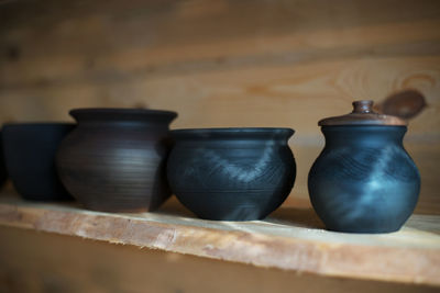 Close-up of pots on shelf at workshop