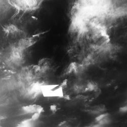 Low angle view of arrow sign against sky